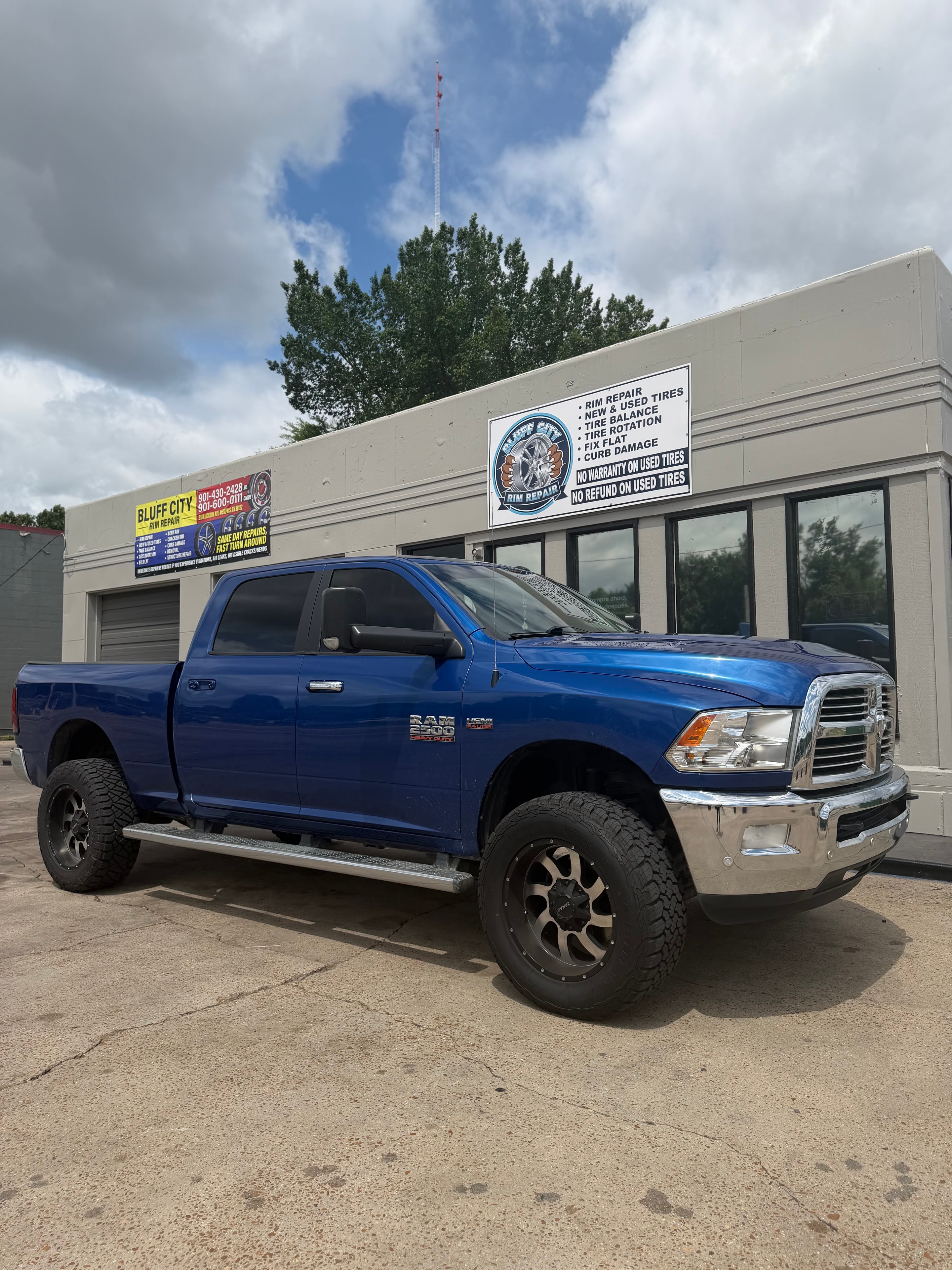 Blue RAM 2500 in front of Bluff City Rim Repair shop