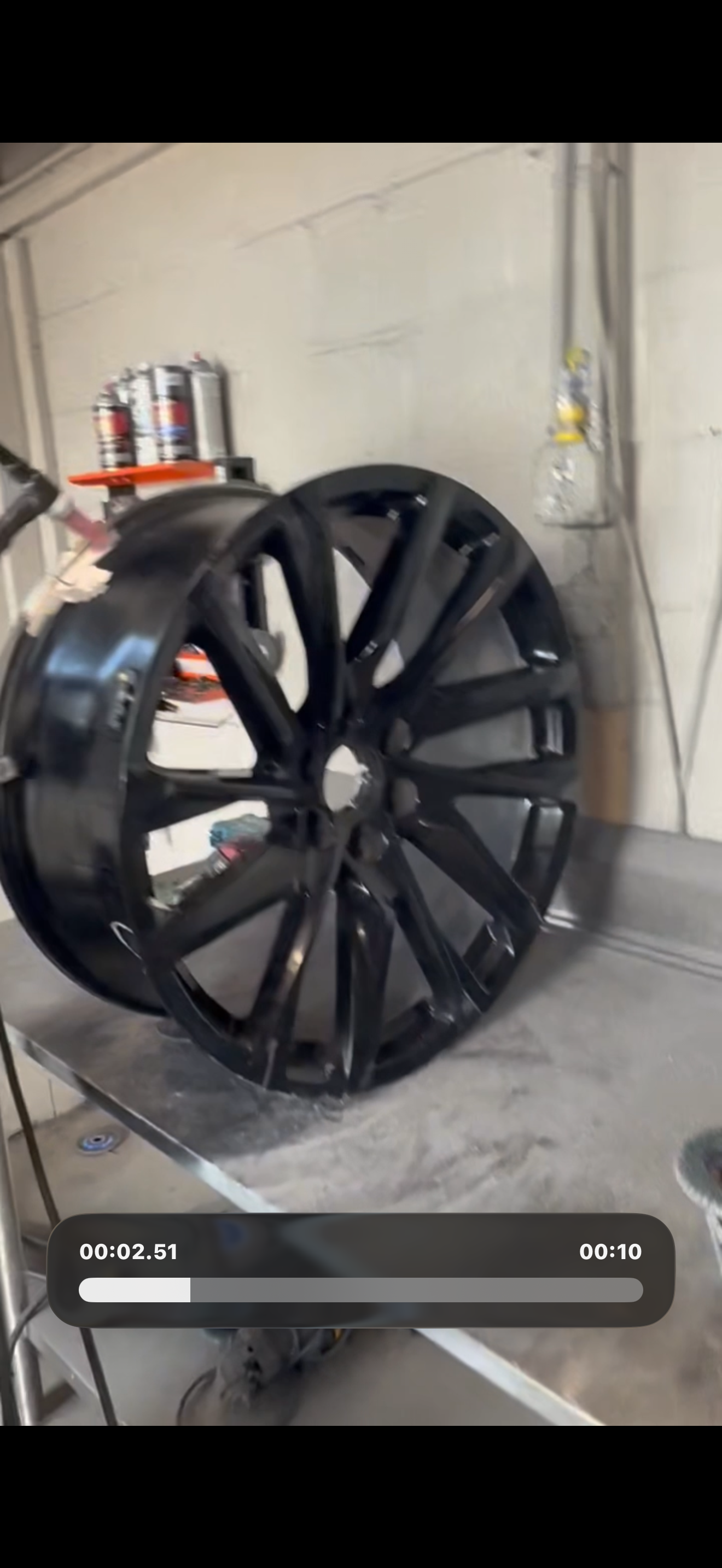 Wheel being painted gloss black in the shop